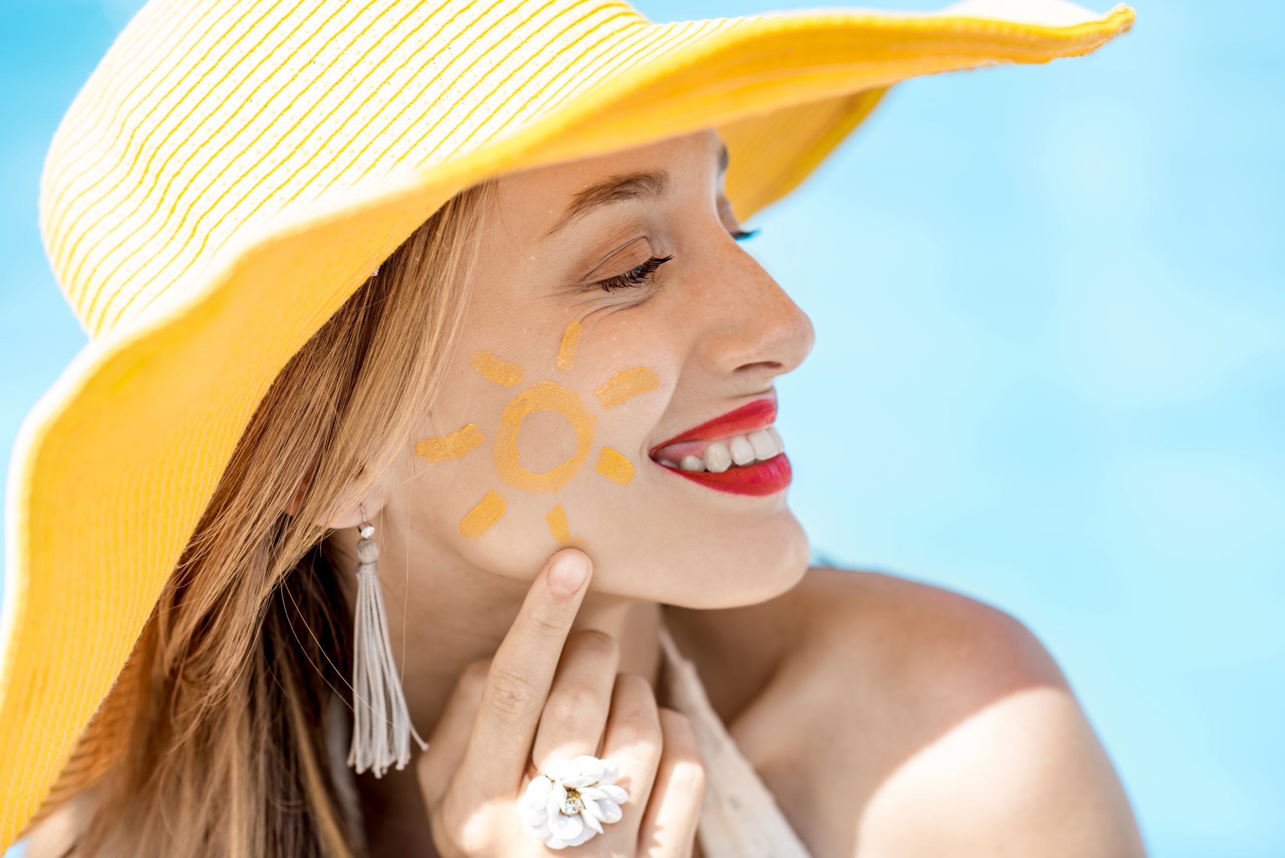 Applying daily sunscreen to protect skin from further sun damage.
