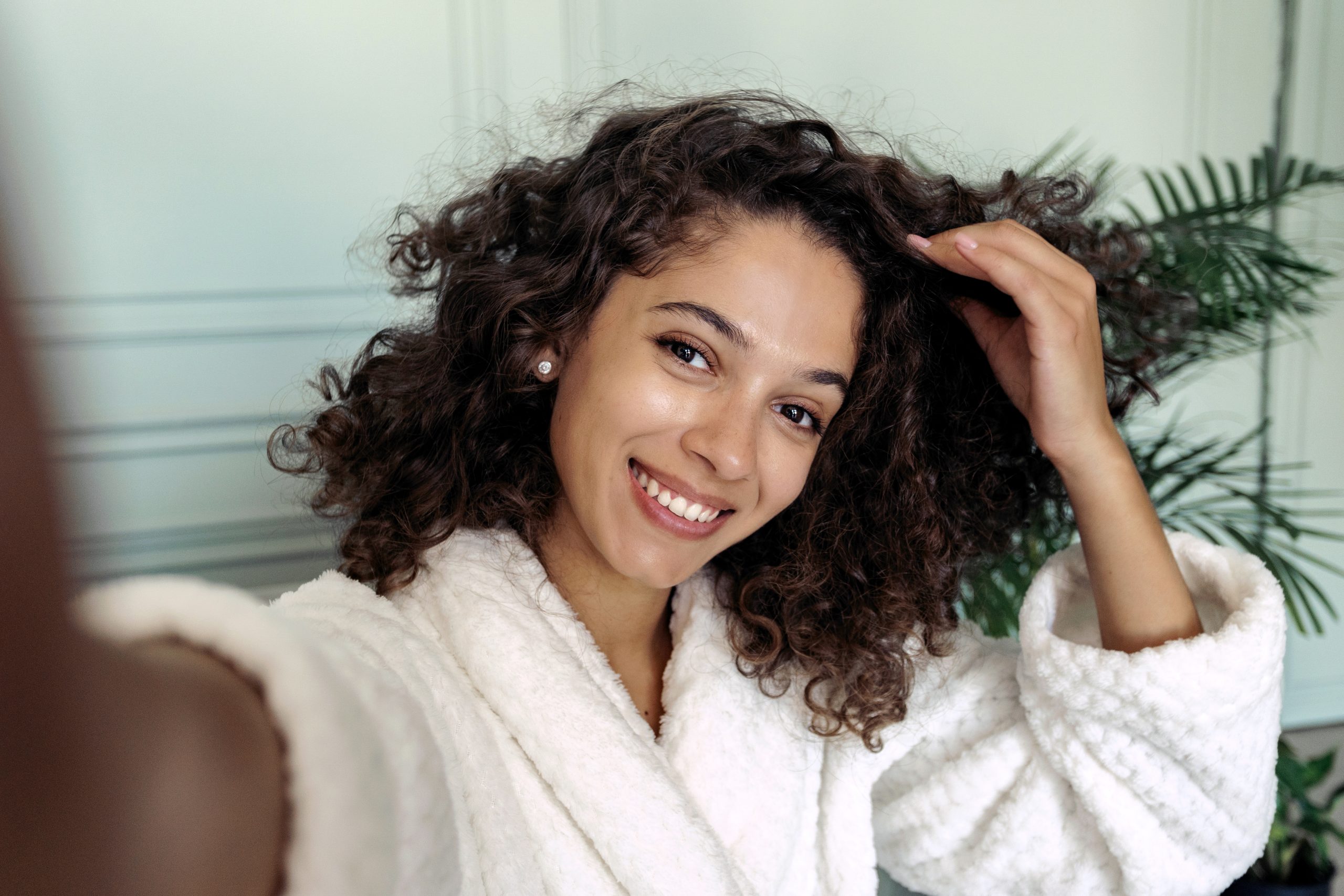 Applying leave-in conditioner and oil to curly hair.