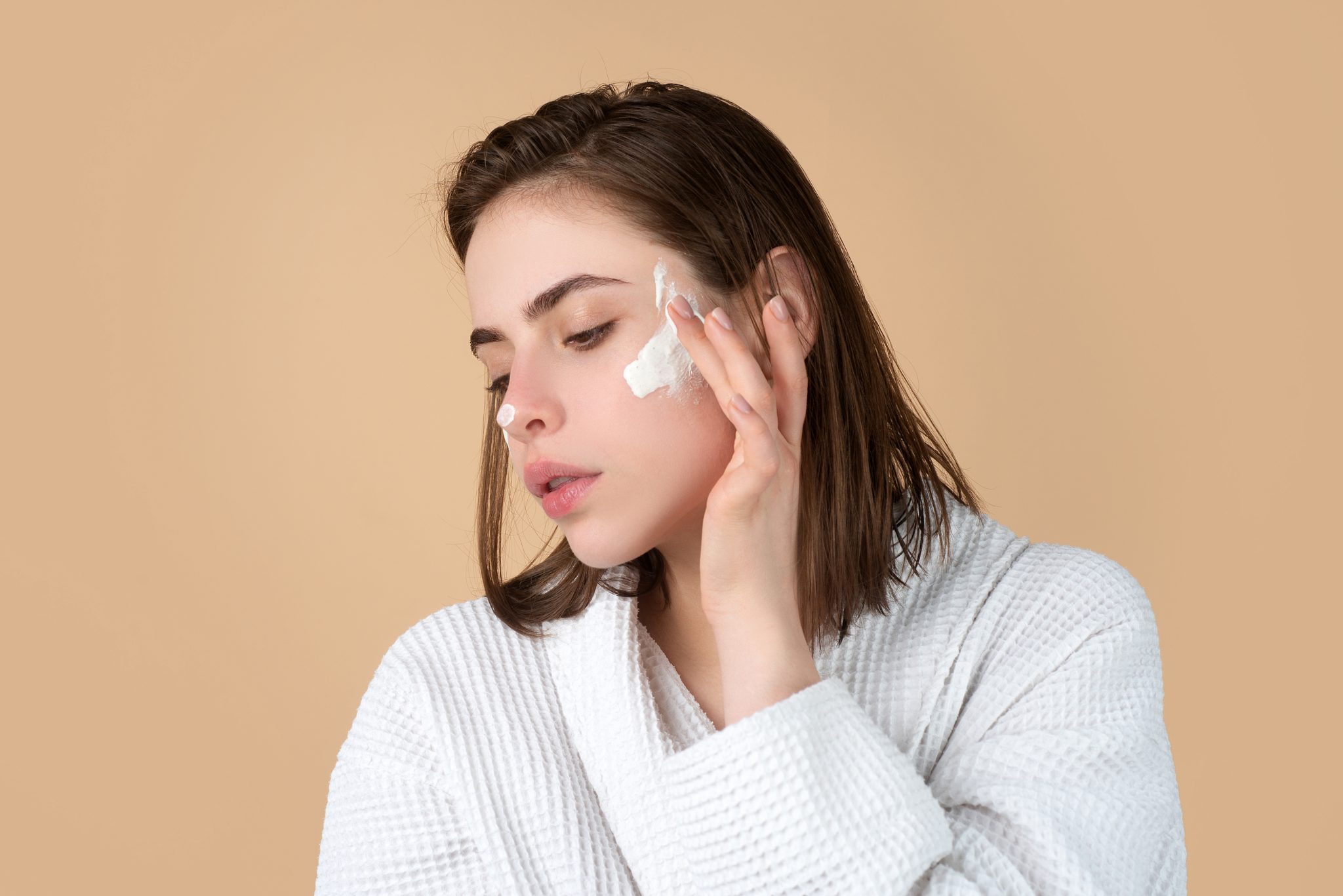 Applying gentle moisturizer on face for sensitive skin care and hydration.