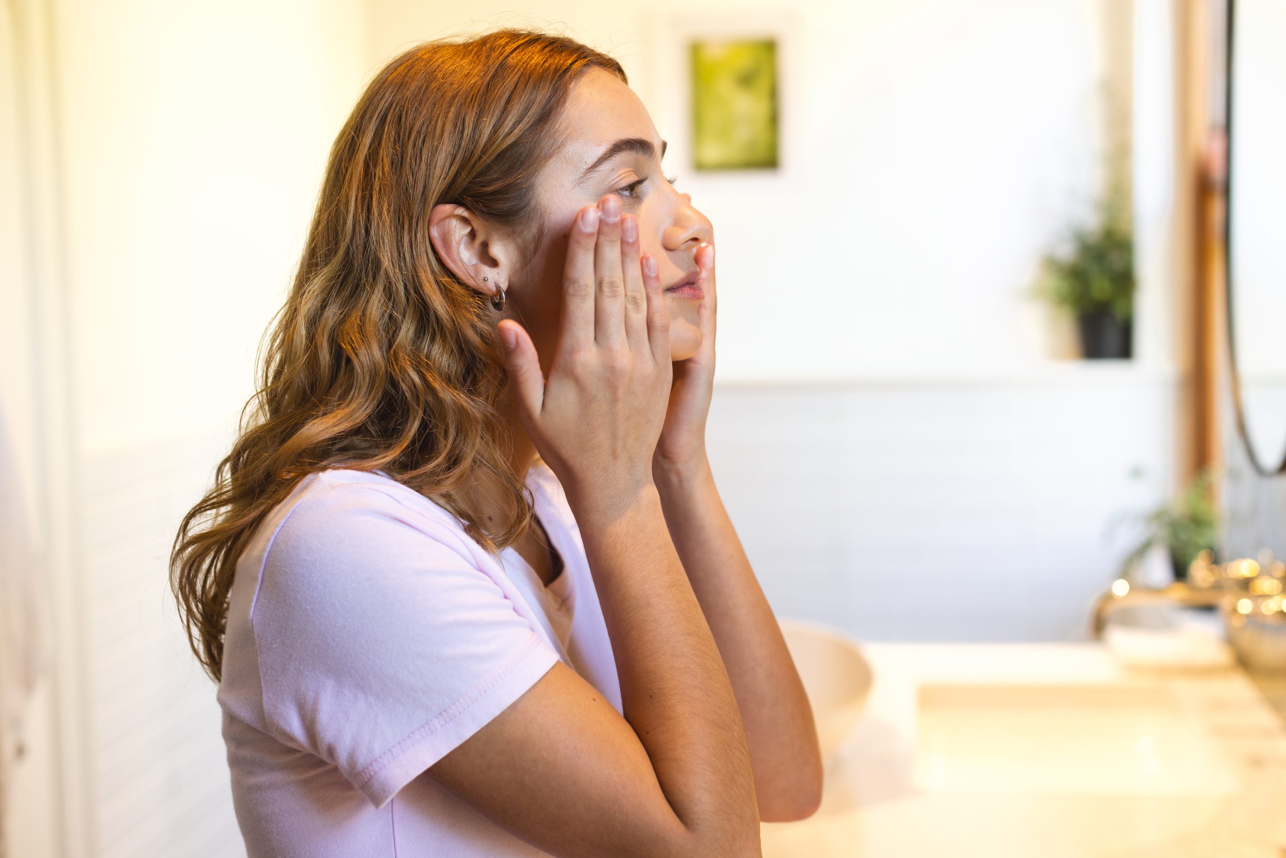 Woman with redness and irritation on cheek indicating sensitive skin signs