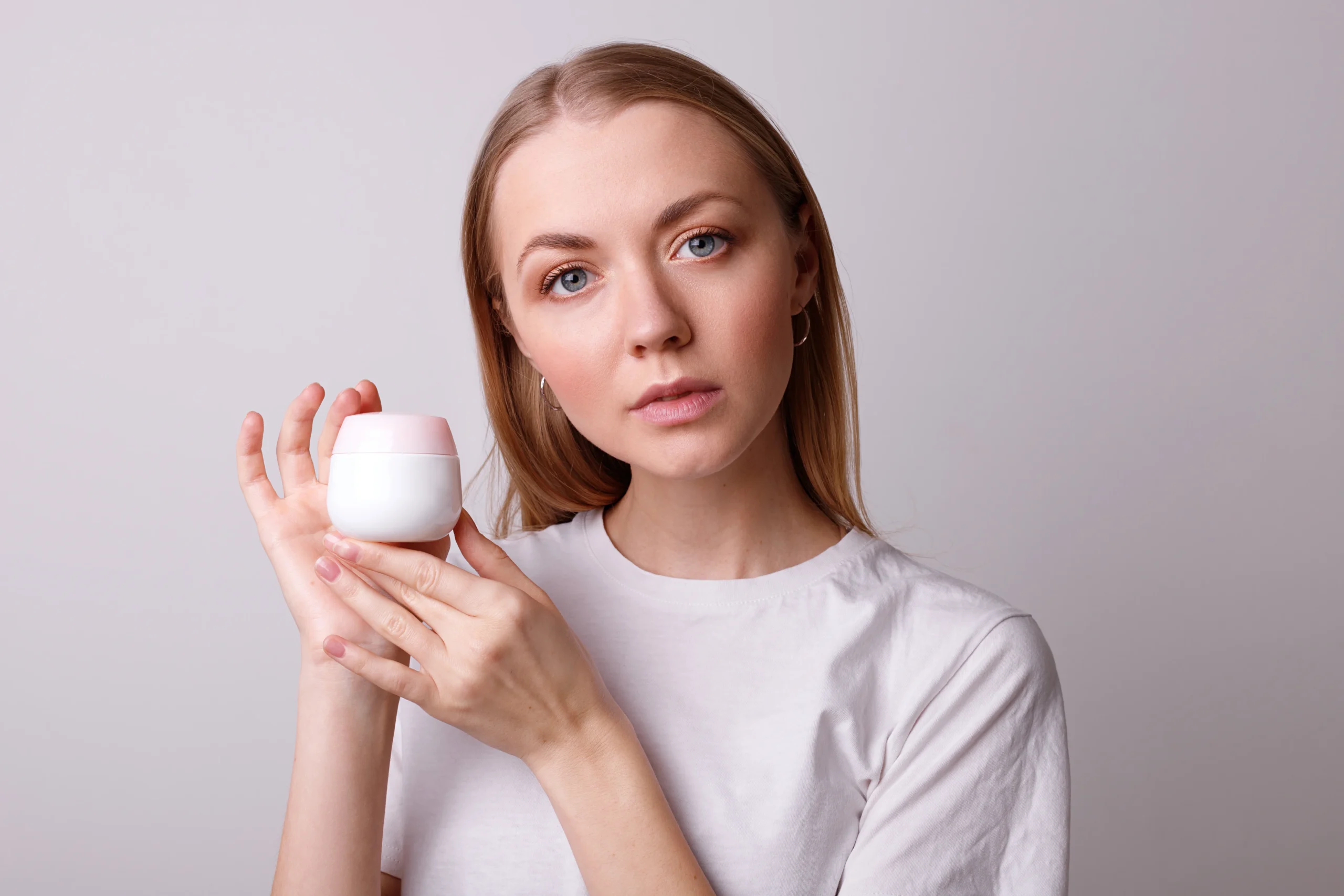 Applying moisturizer before foundation for smooth, even makeup coverage.