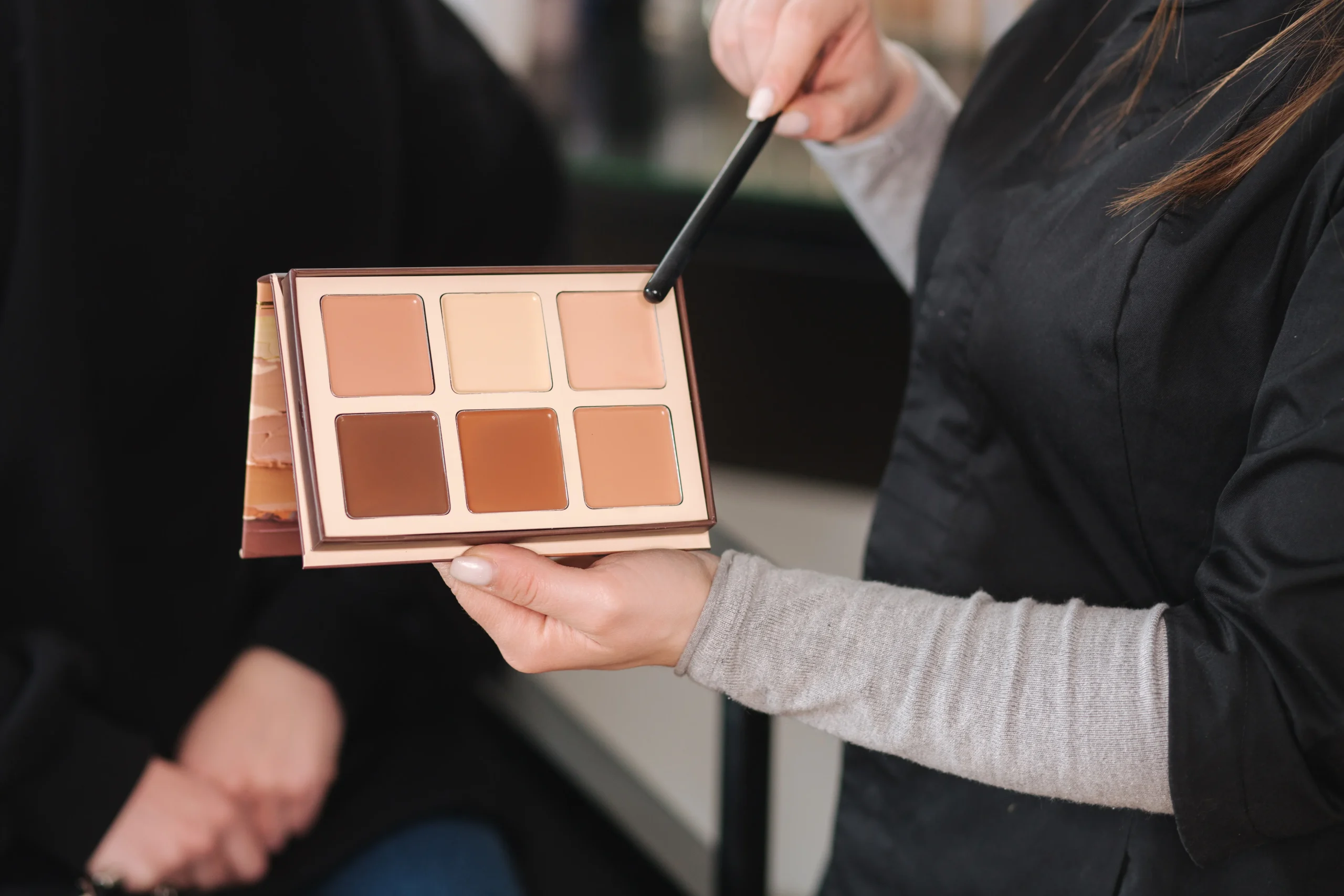 A flat lay of step-by-step color correcting products—from moisturizer to setting spray—demonstrating the correct layering technique.