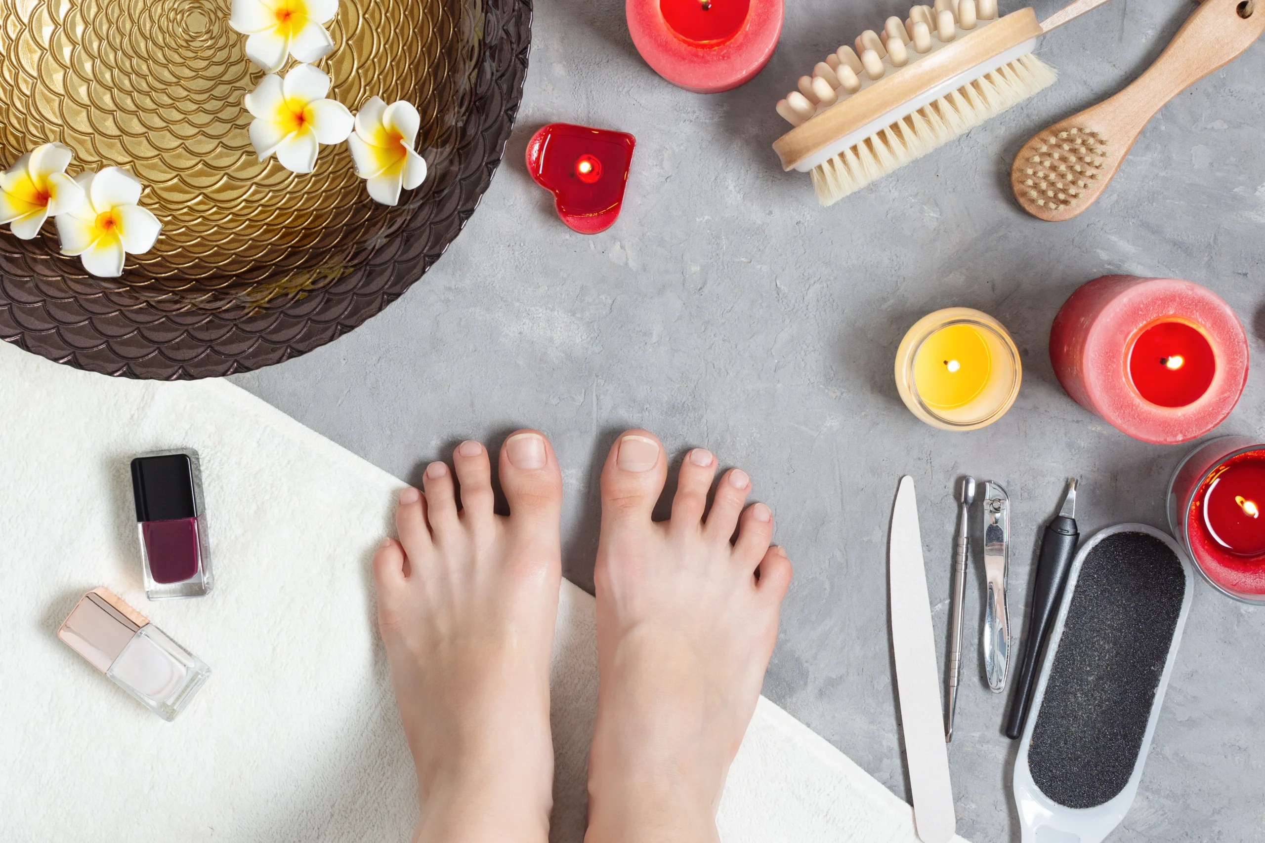 Relaxing home foot soak with warm water and flowers.