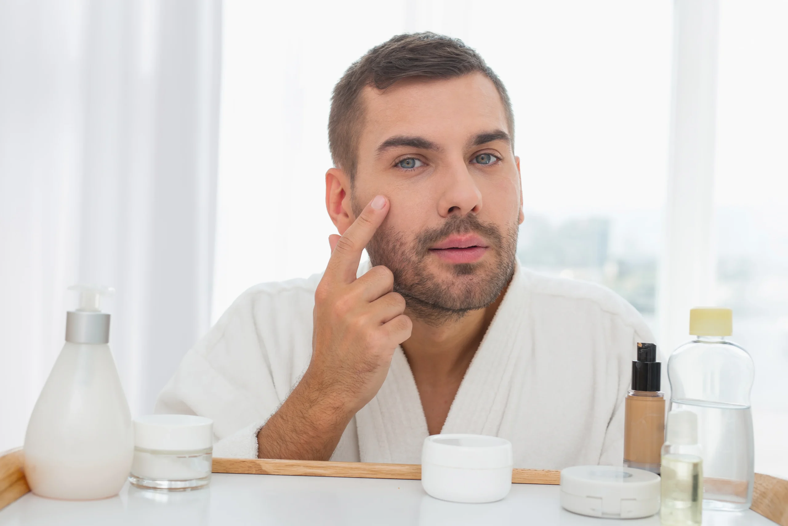 Man applying moisturizer to his face as part of a daily skincare routine.