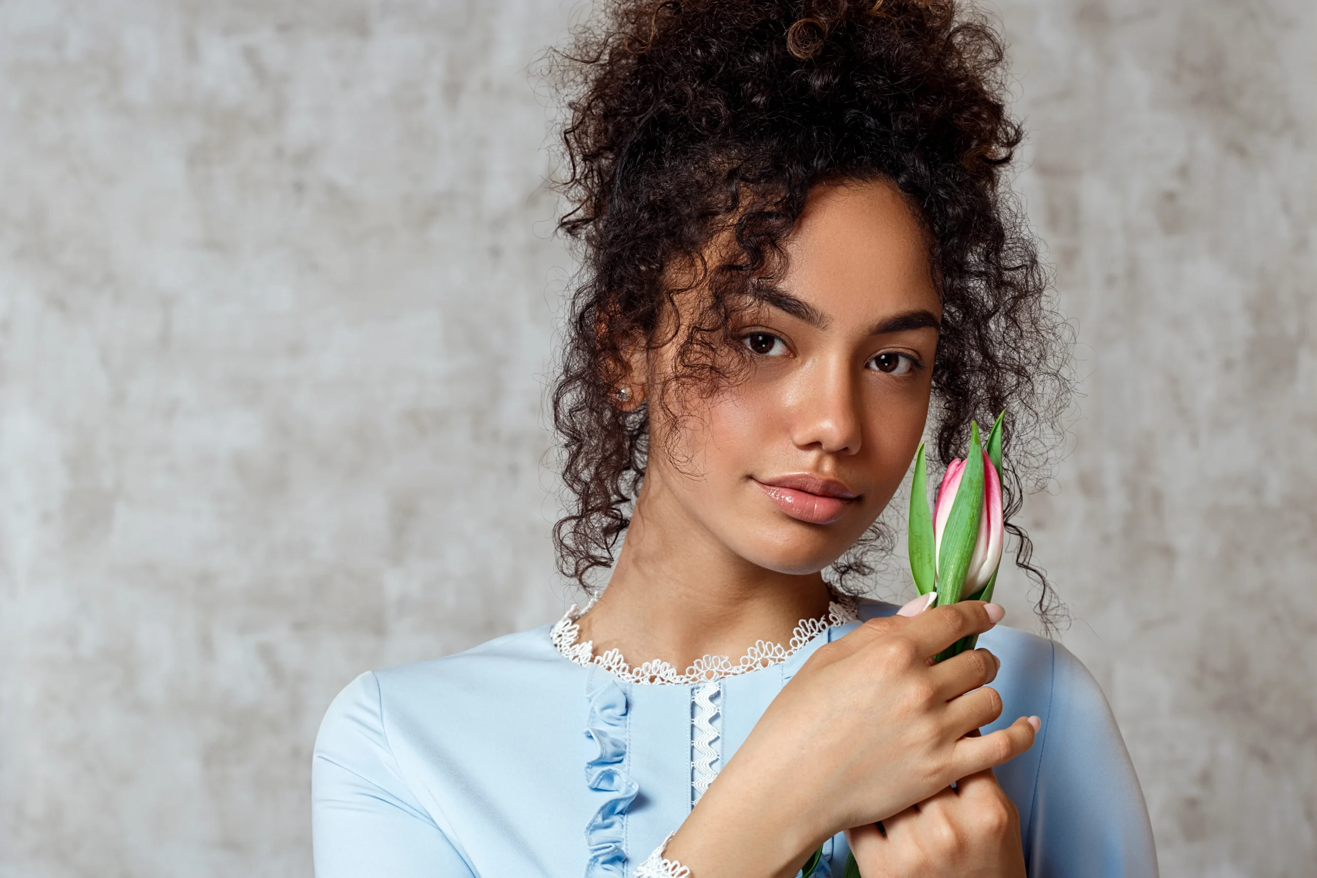 Woman washing natural hair with sulfate-free shampoo for healthy curls.