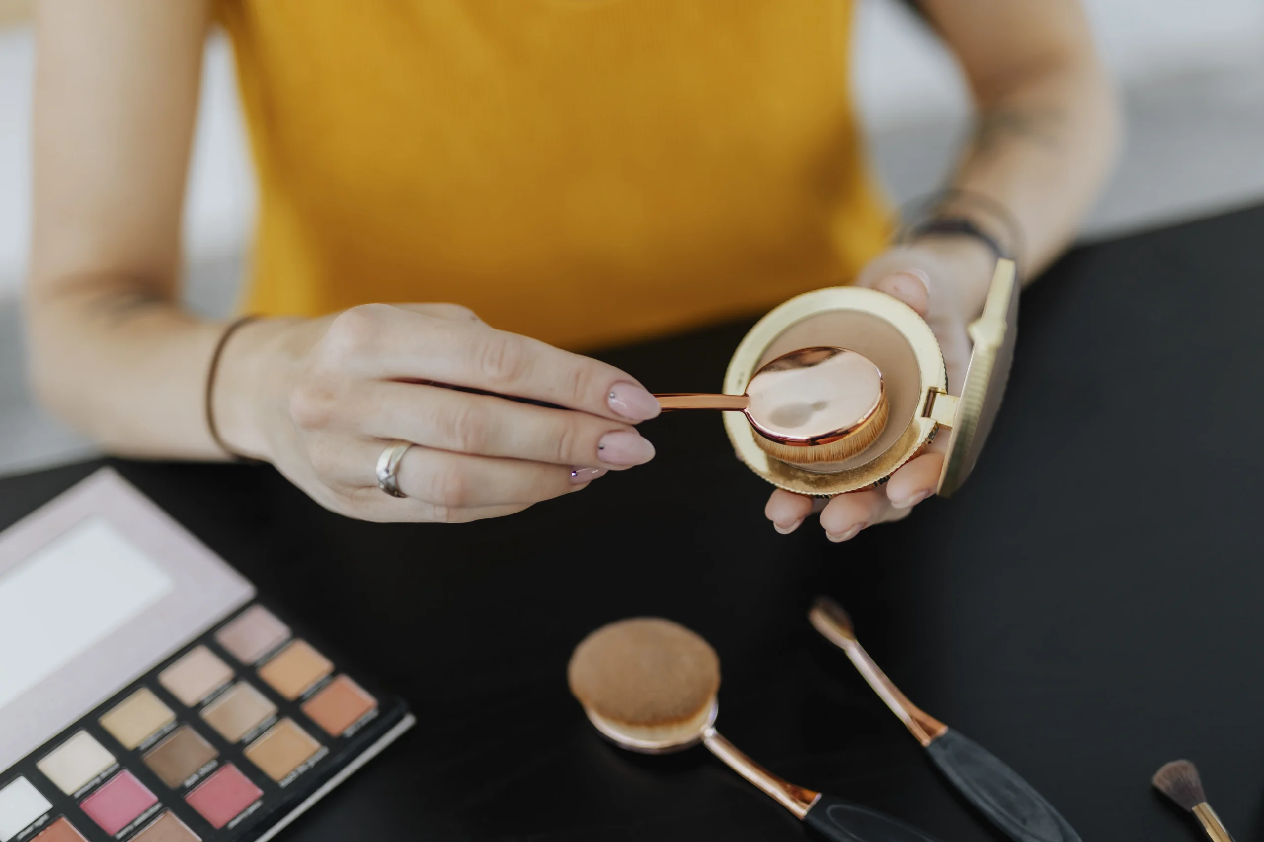 Blending color correctors with a makeup sponge for even skin tone