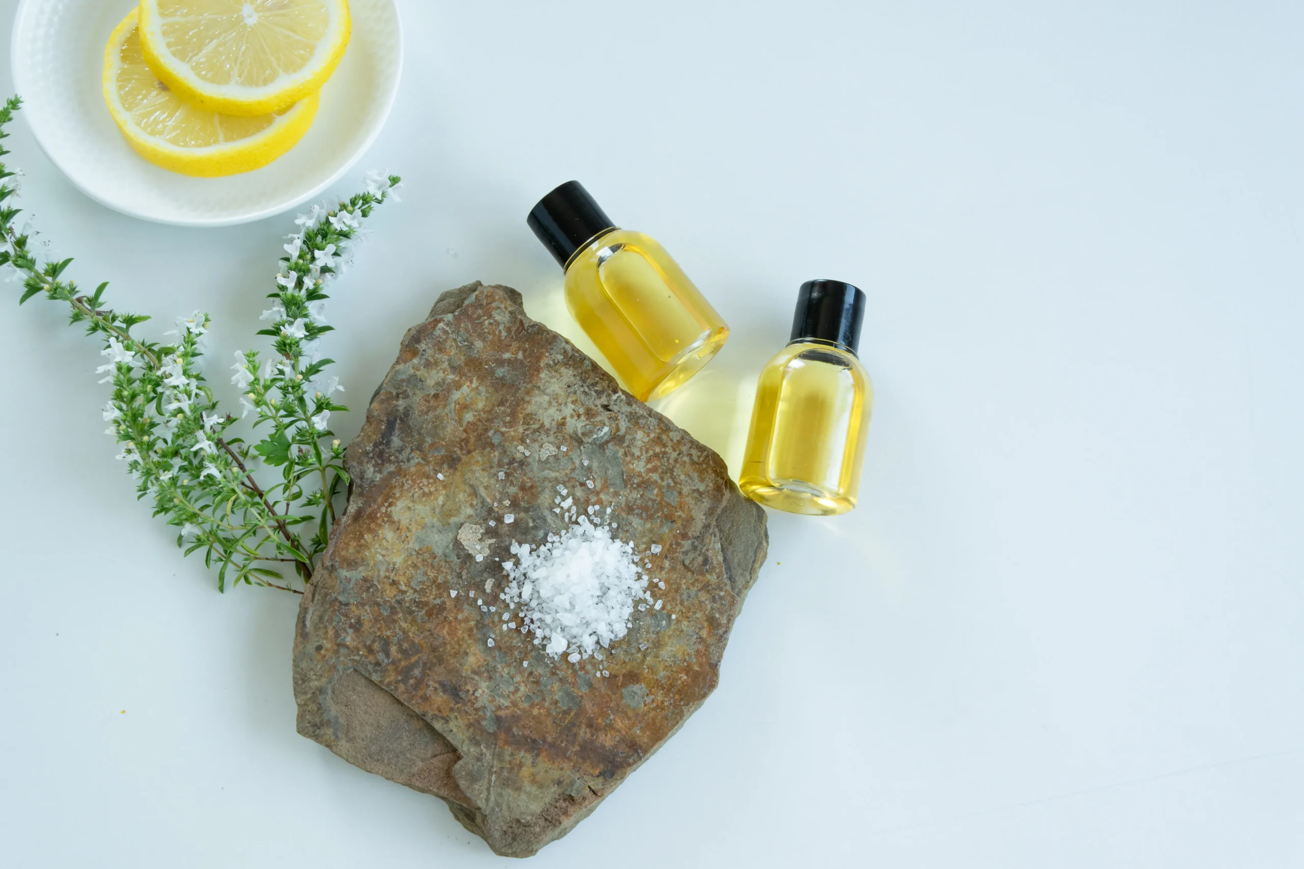 Jo Malone Wood Sage & Sea Salt perfume bottle placed on seaside rocks